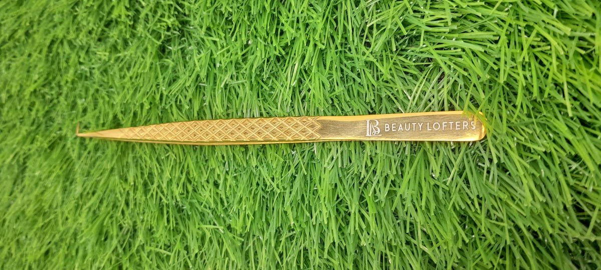 Beauty Lofters 49° Gold Tweezer – Beauty Lofters branding close-up